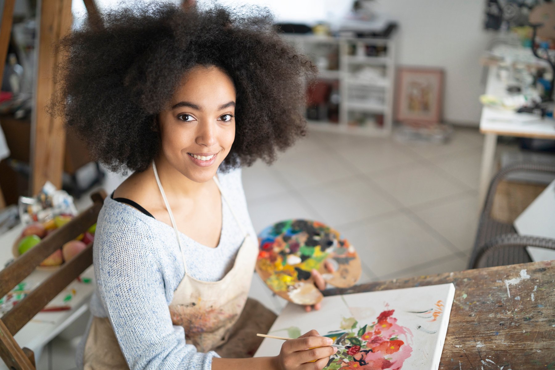 Smiling african fine artist working in studio